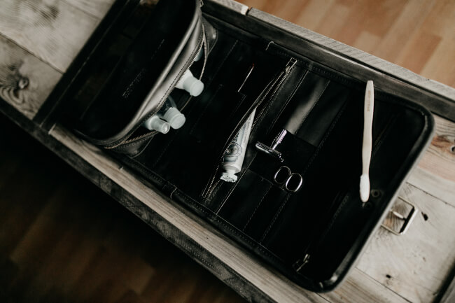 Open Kruk Garage leather Wash Roll displaying organized toiletries and grooming essentials, perfect for travel.